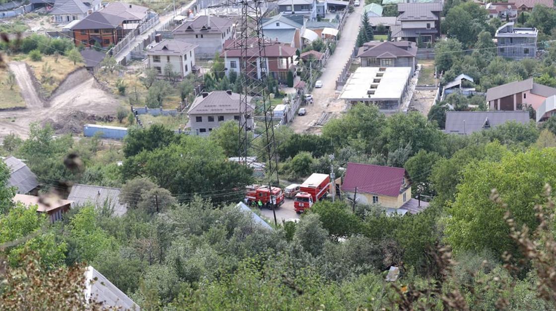 Пожарные машины стоят у домов под горой