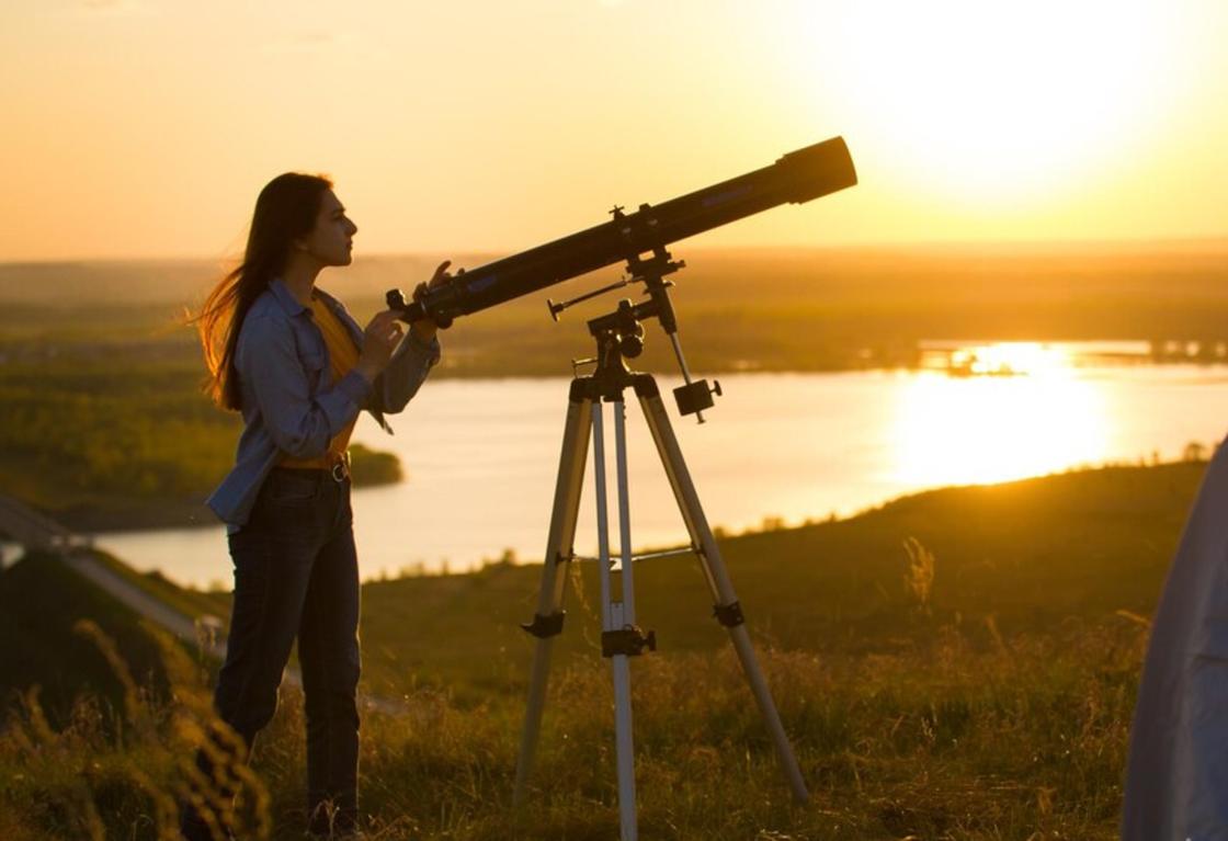 Девушка смотрит в телескоп