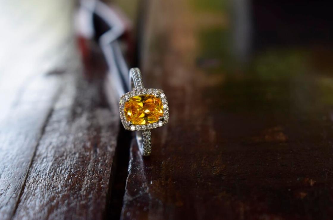 Кольцо с желтым камнем на столе