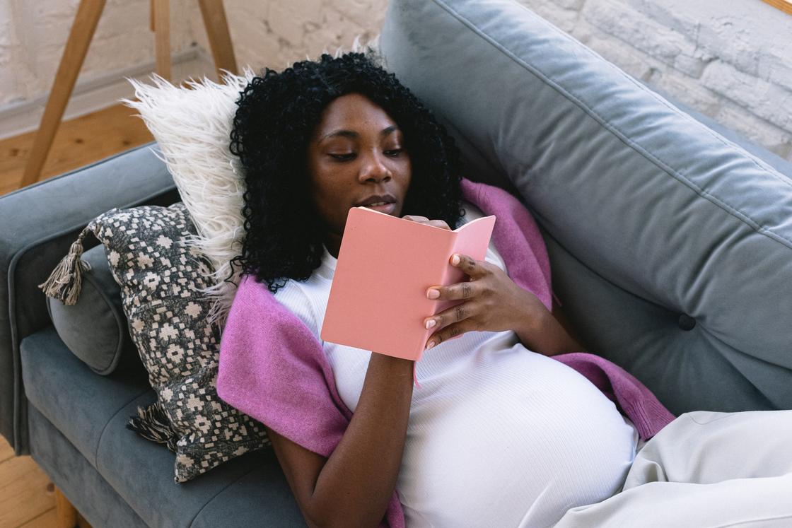 Беременная женщина записывает в блокнот