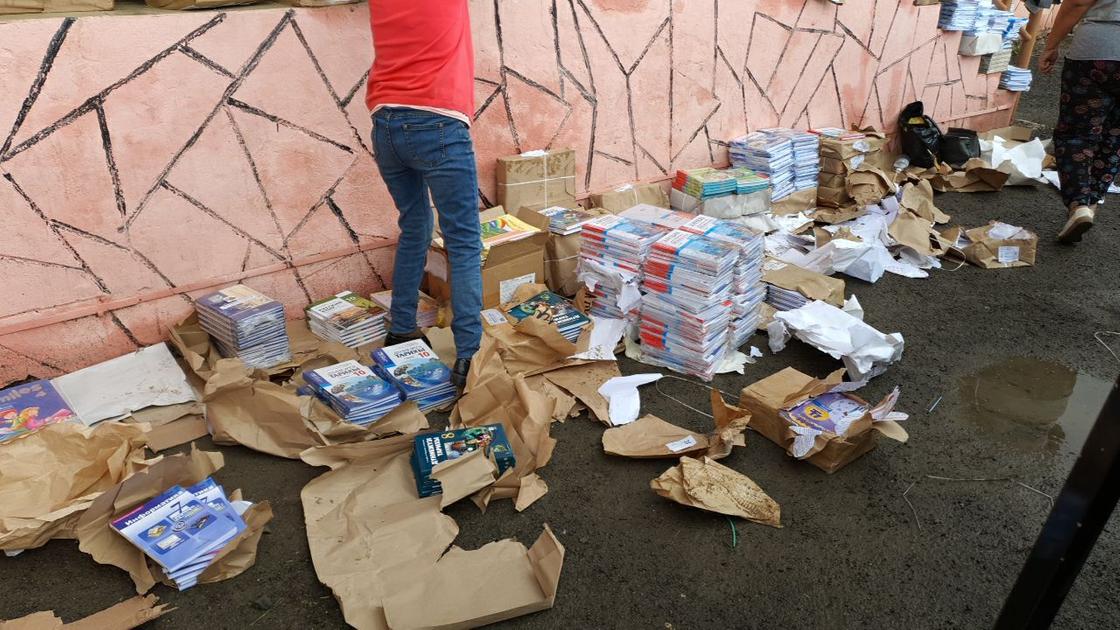 Коробки с учебниками, стоящие в лужах, попали на видео в Атырау