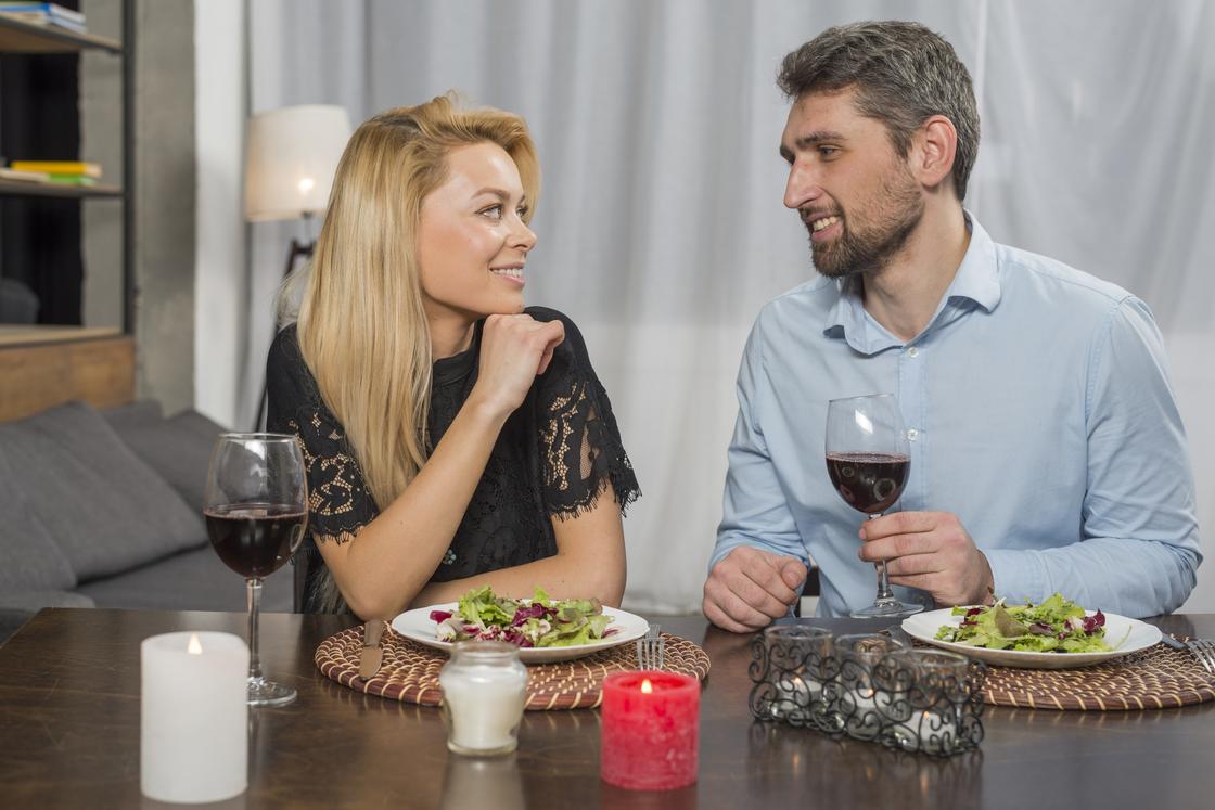 Мужчина и женщина едят и пьют вино