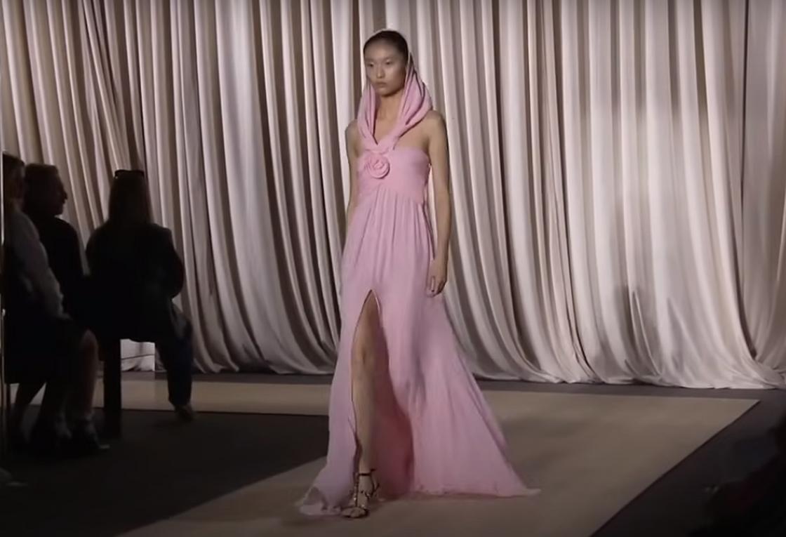 Модель демонстрирует розовое платье с капюшоном, украшенное розой из ткани от Giambattista Valli