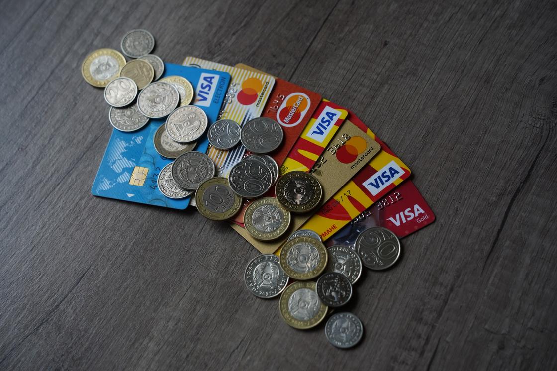 Монеты тенге лежат на банковских картах