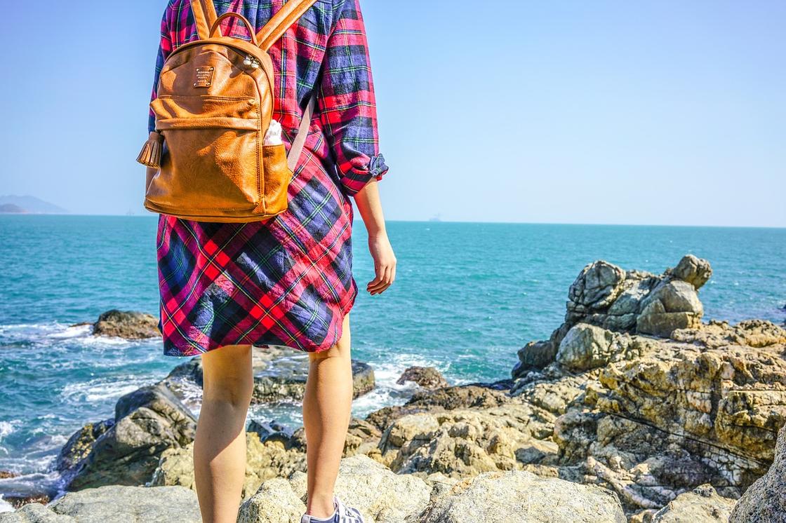 Девушка с рюкзаком на пляже