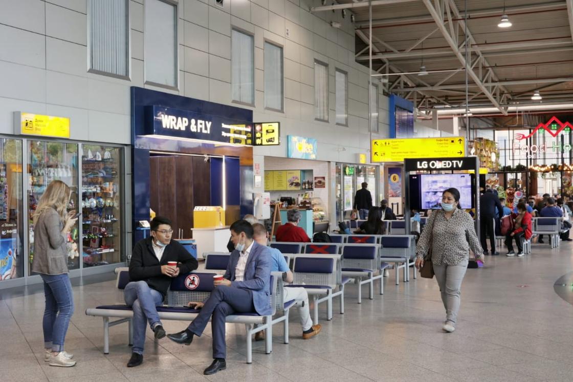 Люди сидят в алматинском аэропорту
