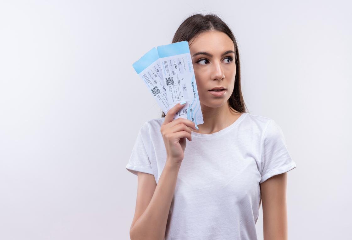 Девушка в белой футболке держит у лица два билета