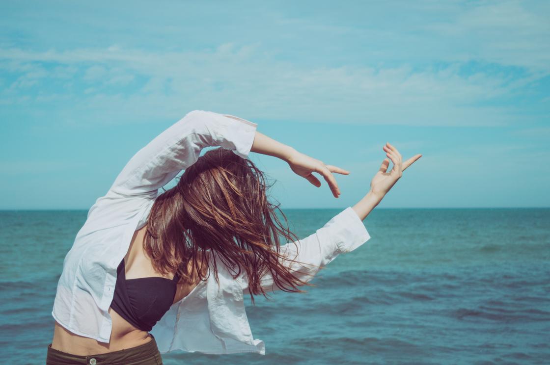 Девушка танцует на фоне моря