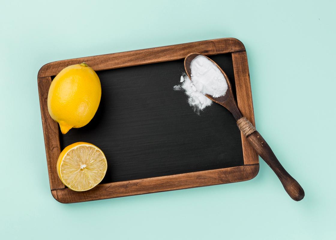 На досточке разрезанный лимон и ложка с содой