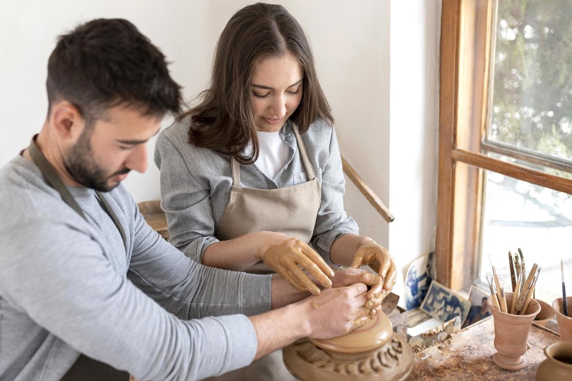 Мужчина и женщина лепят посуду из глины