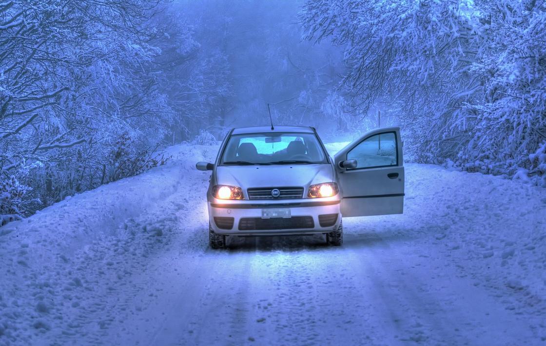 Автомобиль на зимней дороге в условиях плохой видимости