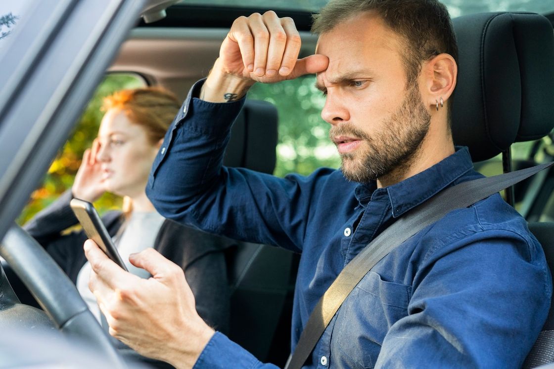Водитель держит в руках смартфон