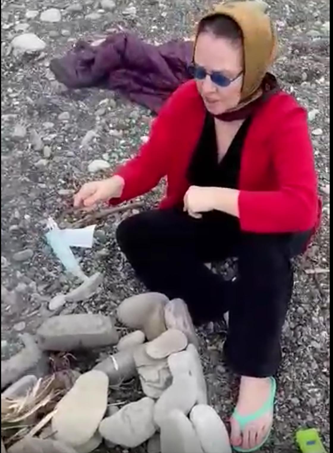 Женщина пытается сжечь маски над костром