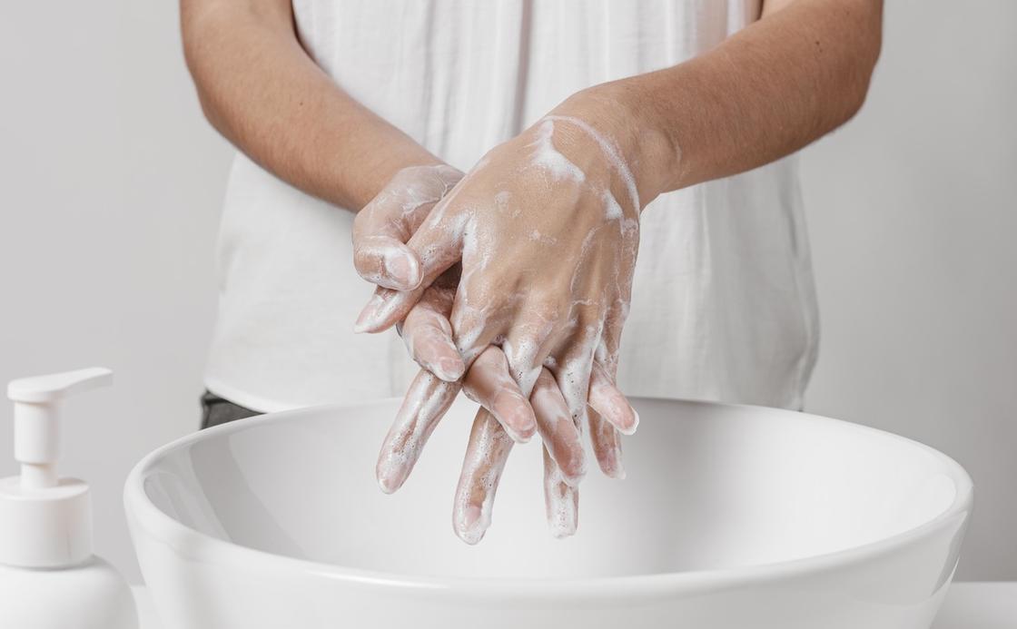 Женщина моет руки мылом в большой белой миске