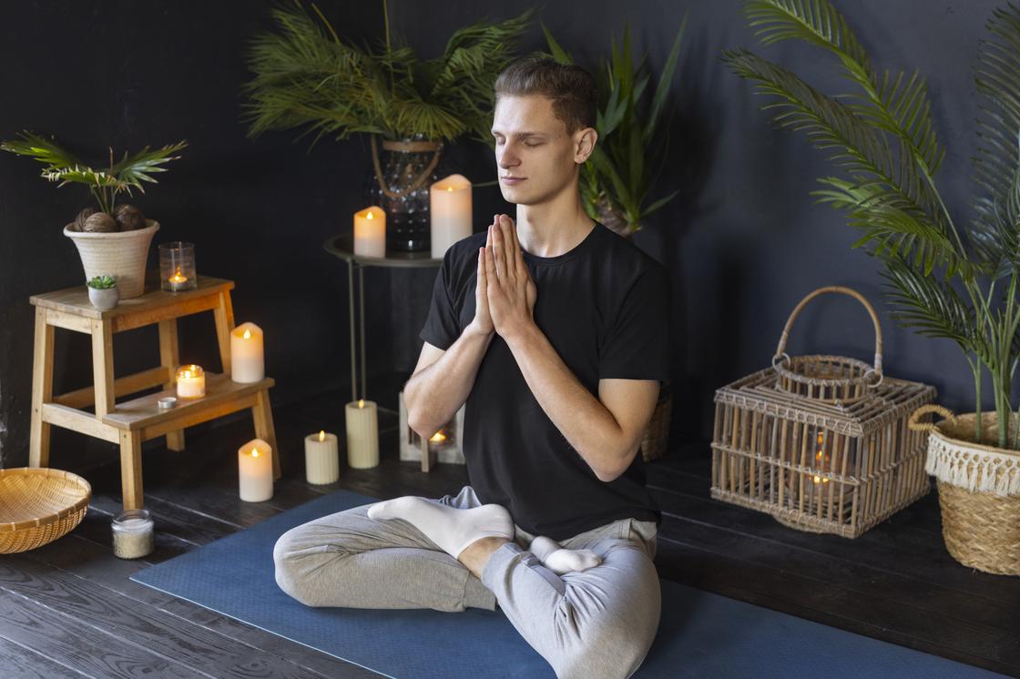 Мужчина медитирует в окружении свечей