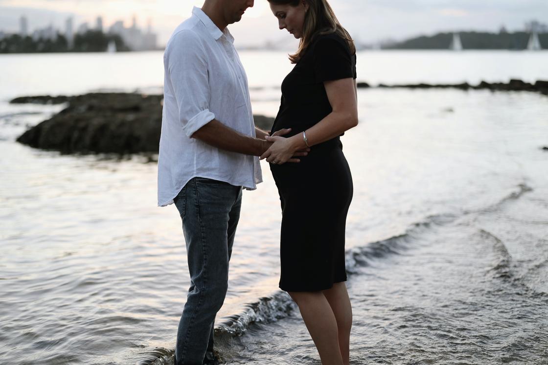 Беременная женщина и мужчина возле моря
