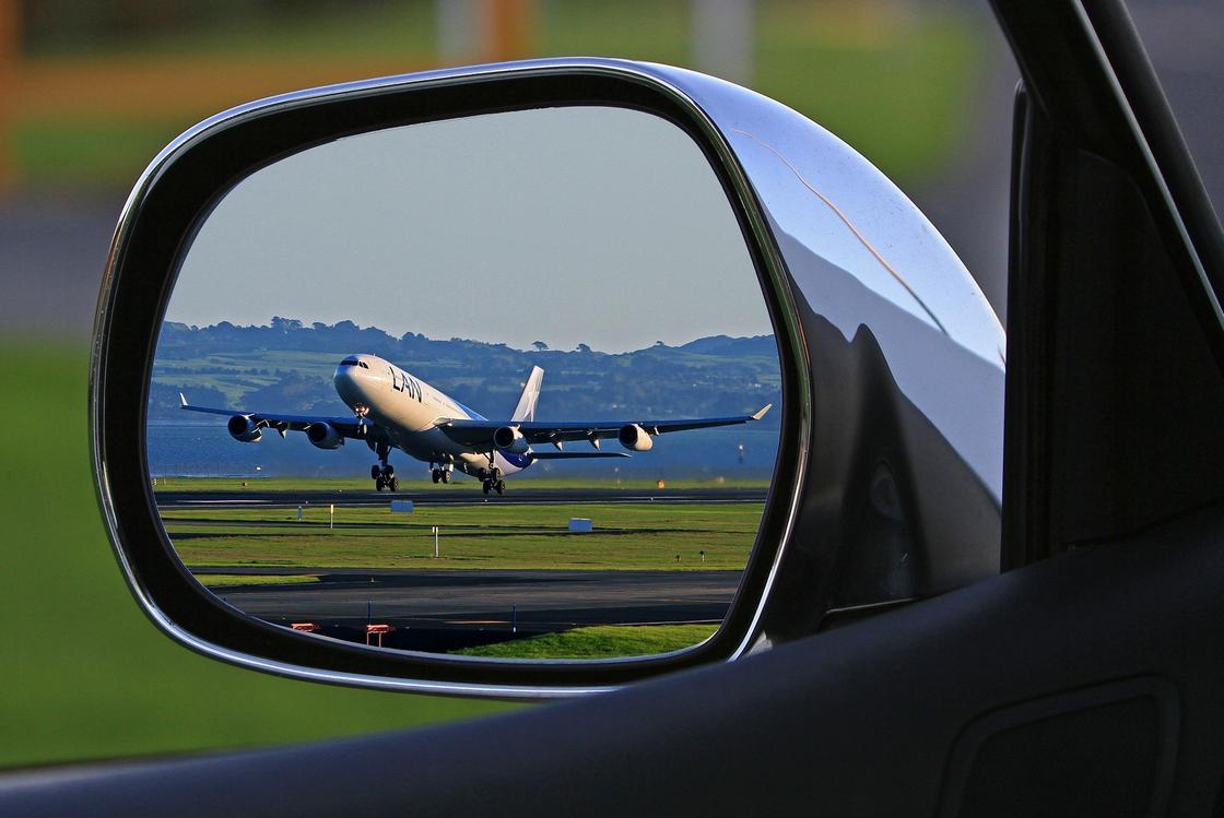 Самолет отражается в зеркале автомобиля