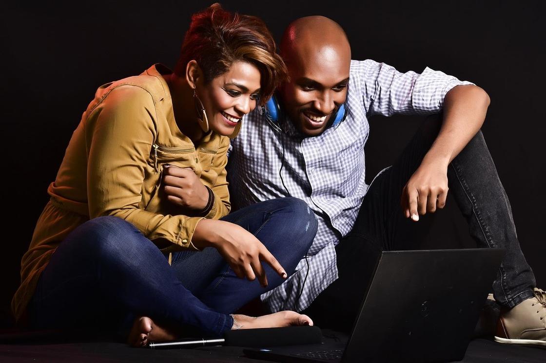 Мужчина и женщина смотрят на экран ноутбука