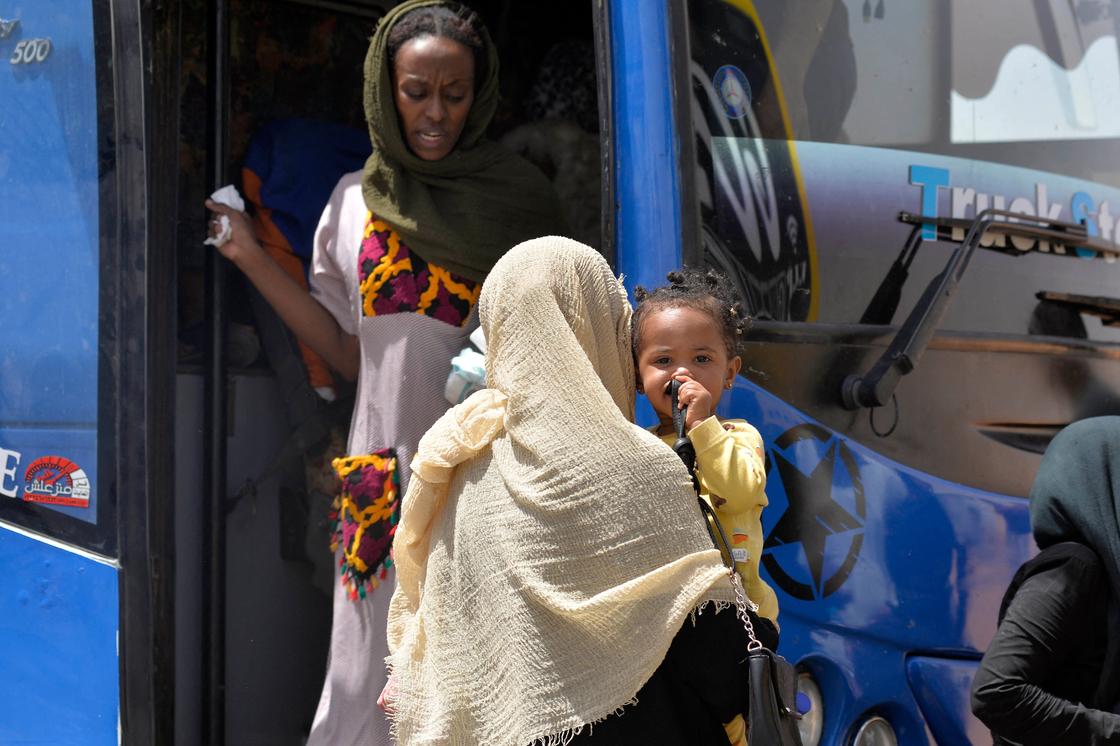 Суданские беженцы садятся в автобус