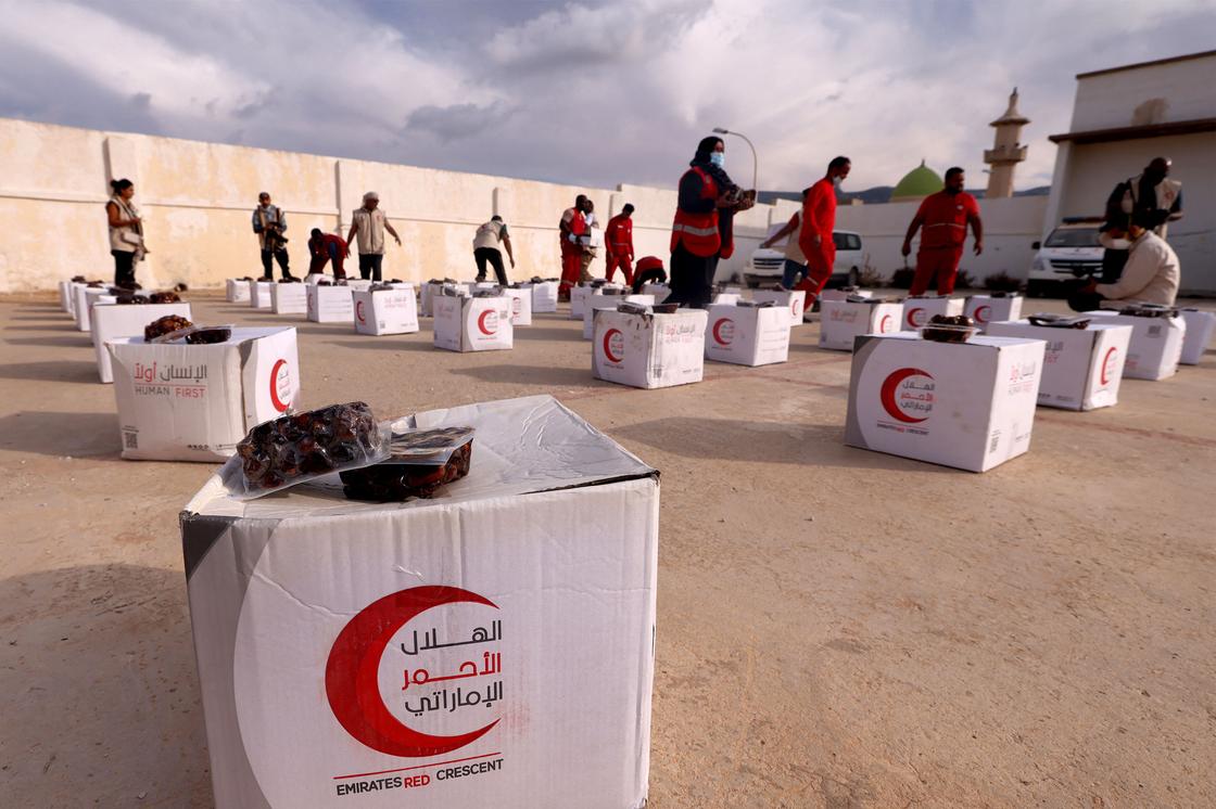 Сотрудники Красного Полумесяца ОАЭ раздают помощь пострадавшим от наводнения в Дерне