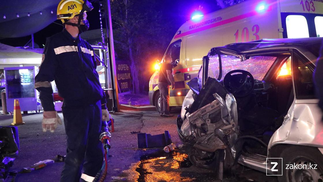 Спасатель у поврежденного авто в Алматы