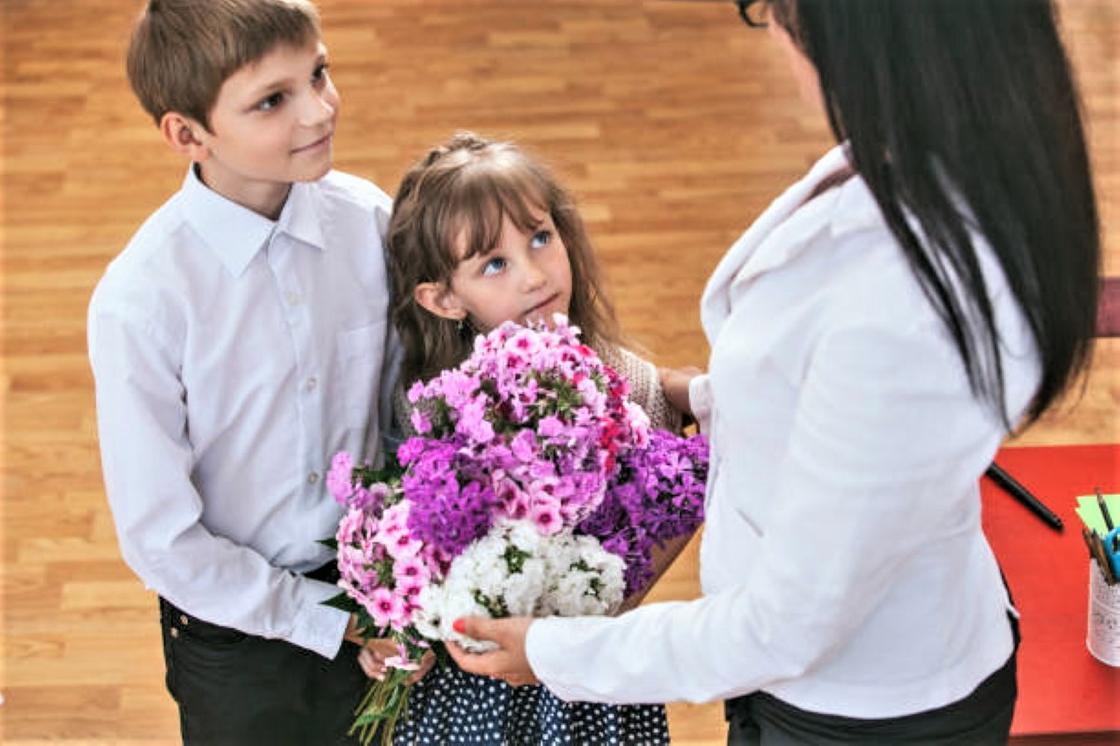 Школьники дарят учителю цветы