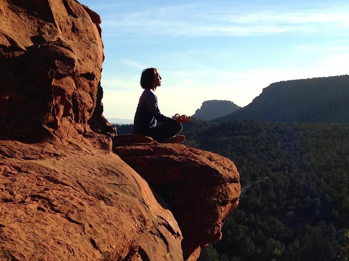 Девушка медитирует на скале