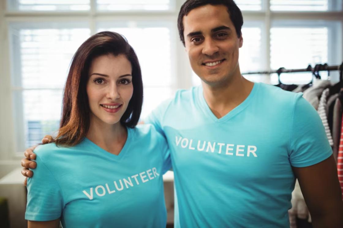Мужчина и женщина в футболках волонтеров