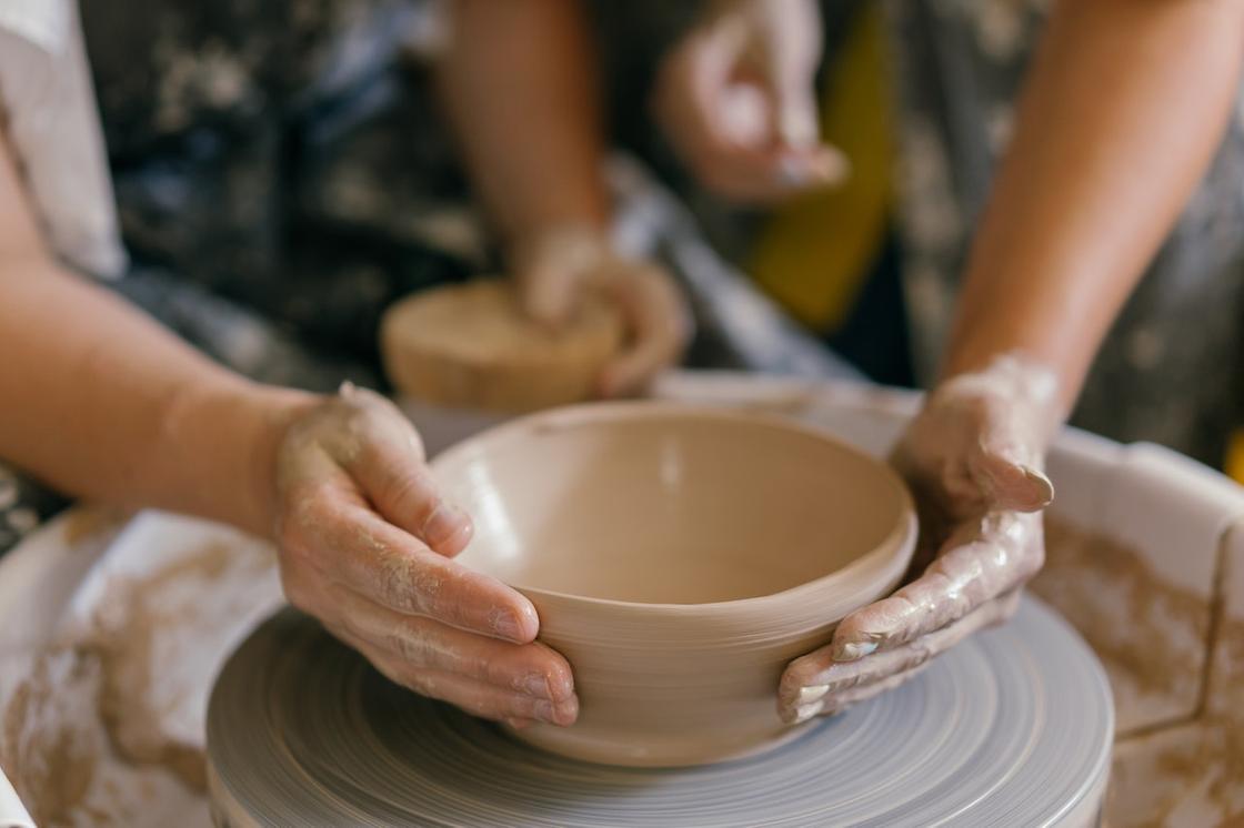 Руки, работающие с глиной на гончарном круге