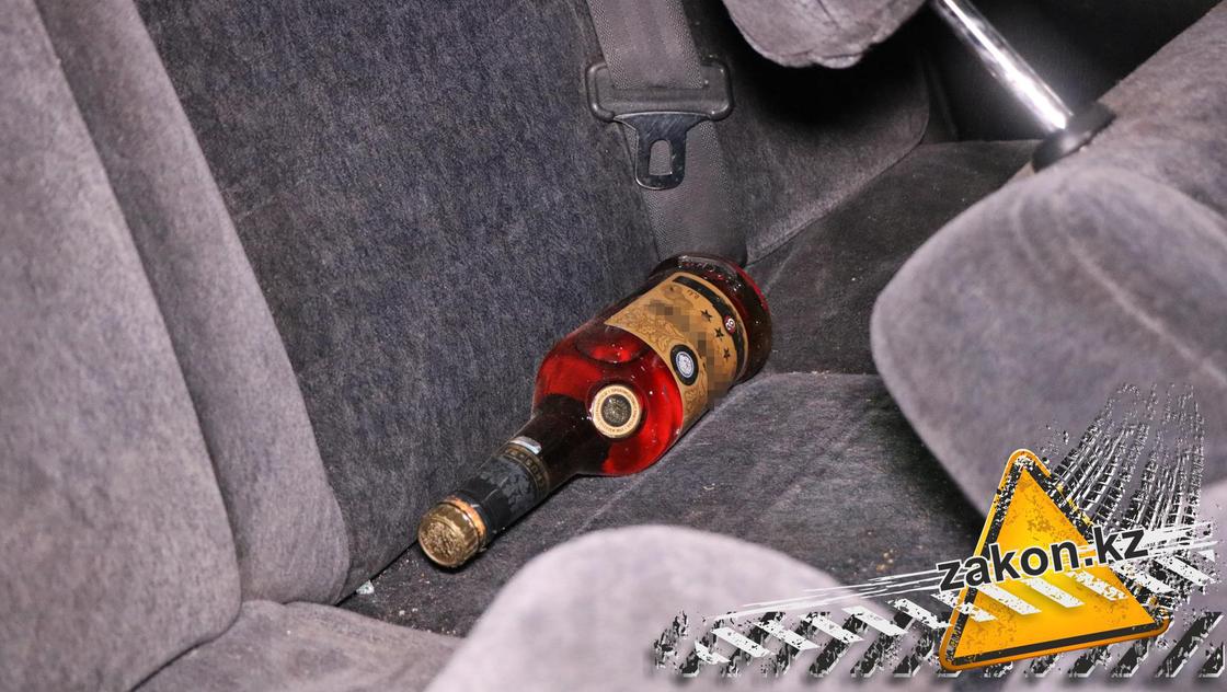 Бутылка алкоголя в салоне машины