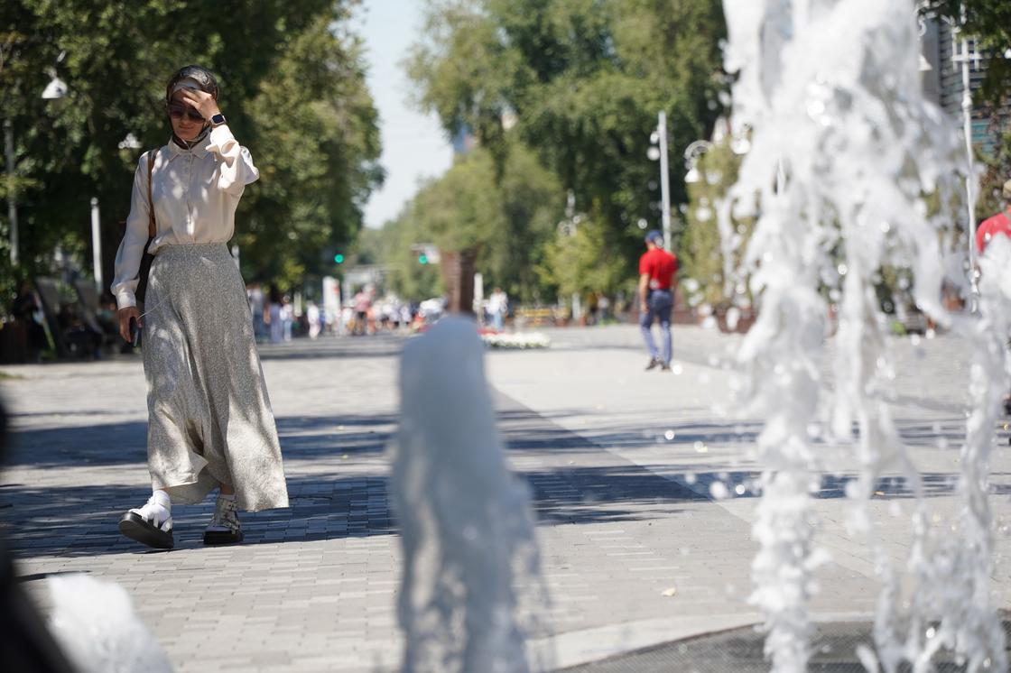Женщина у фонтана в Алматы