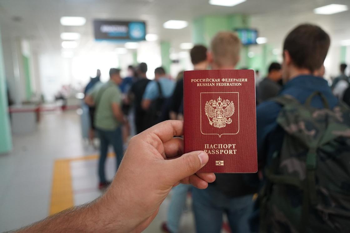 Мужчина держит паспорт в руках