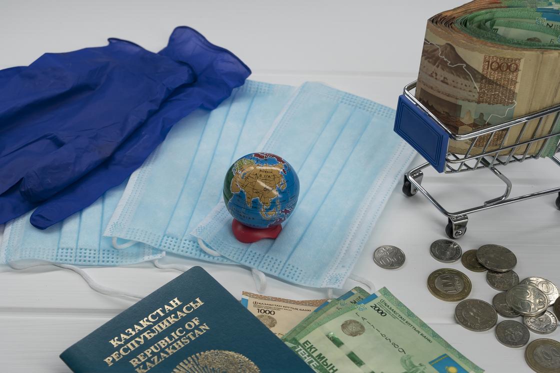 Деньги, медицинские маски, перчатки и паспорт лежат на столе