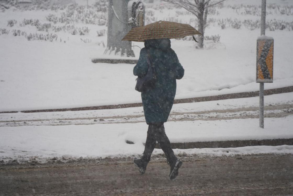 Человек идет по улице в снег