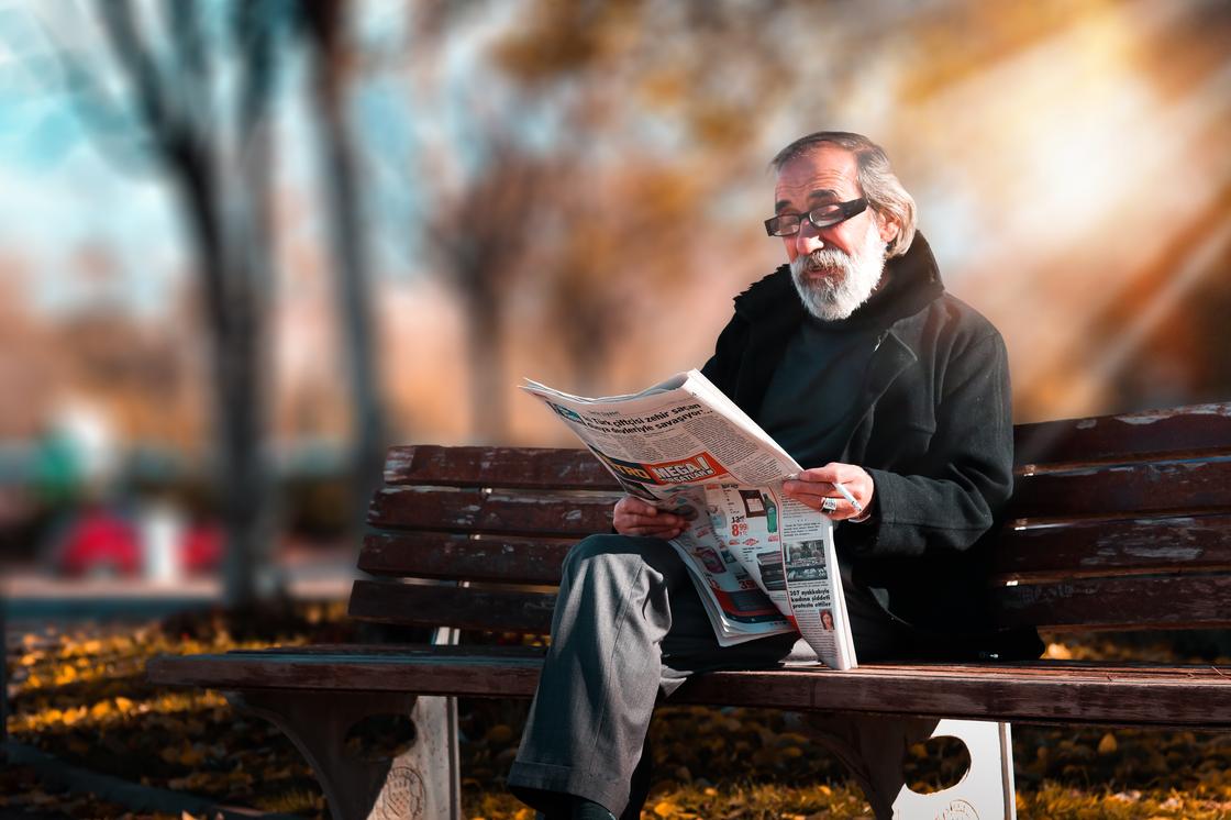 Пожилой мужчина читает газету