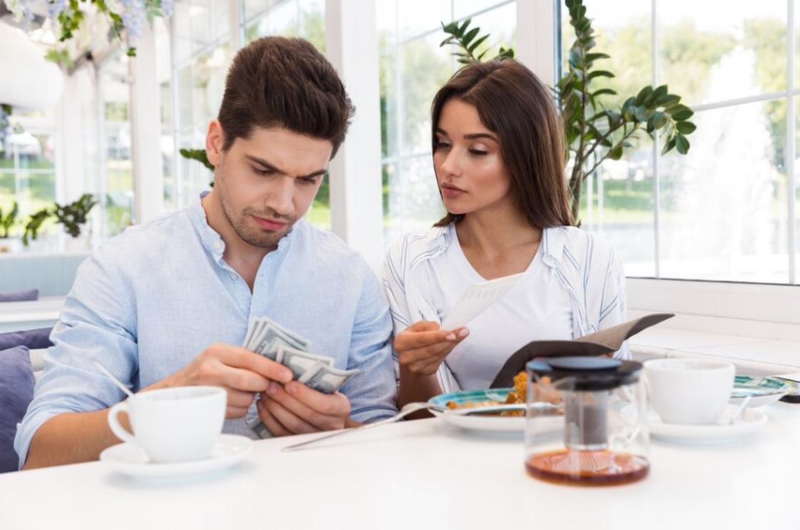 Мужчина и женщина в ресторане считают деньги