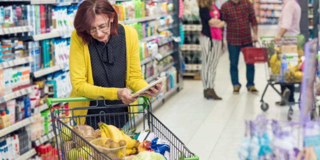 Женщина в супермаркете с корзиной продуктов