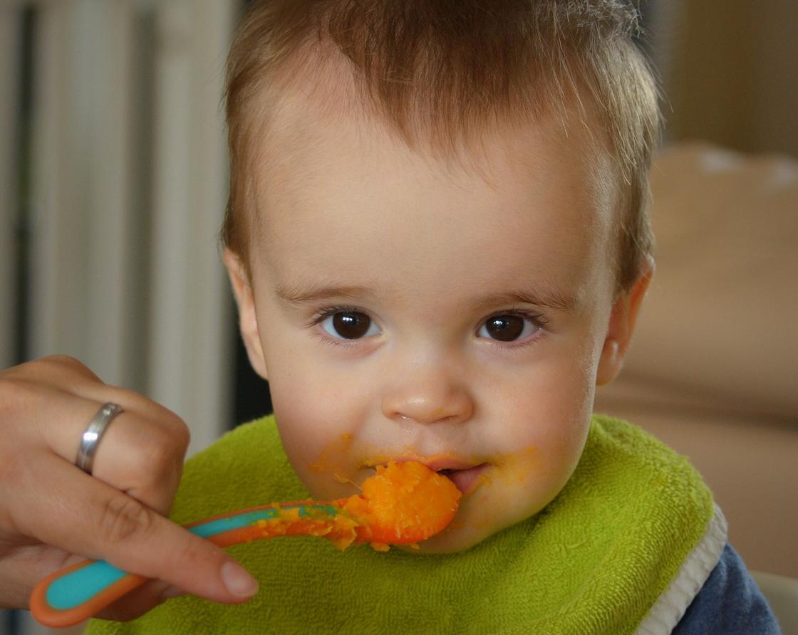 Ребенка кормят с ложки