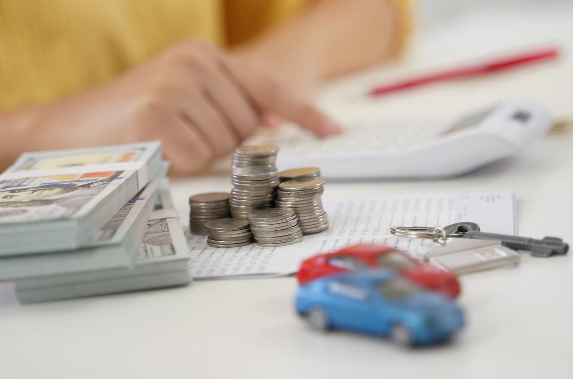 Деньги, ключи от авто и модели машины на столе