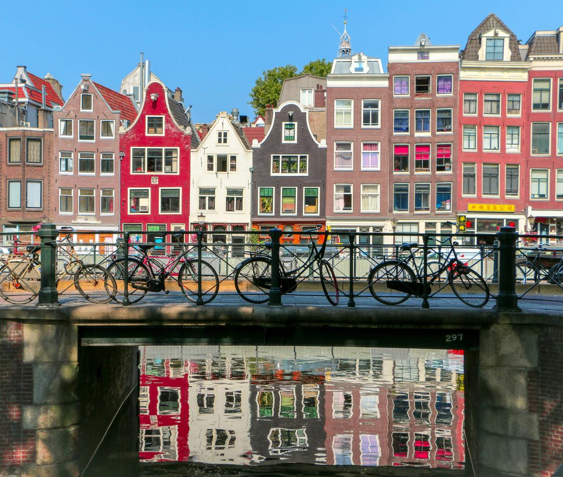 Вид на разноцветные домики и мост, на котором стоят велосипеды