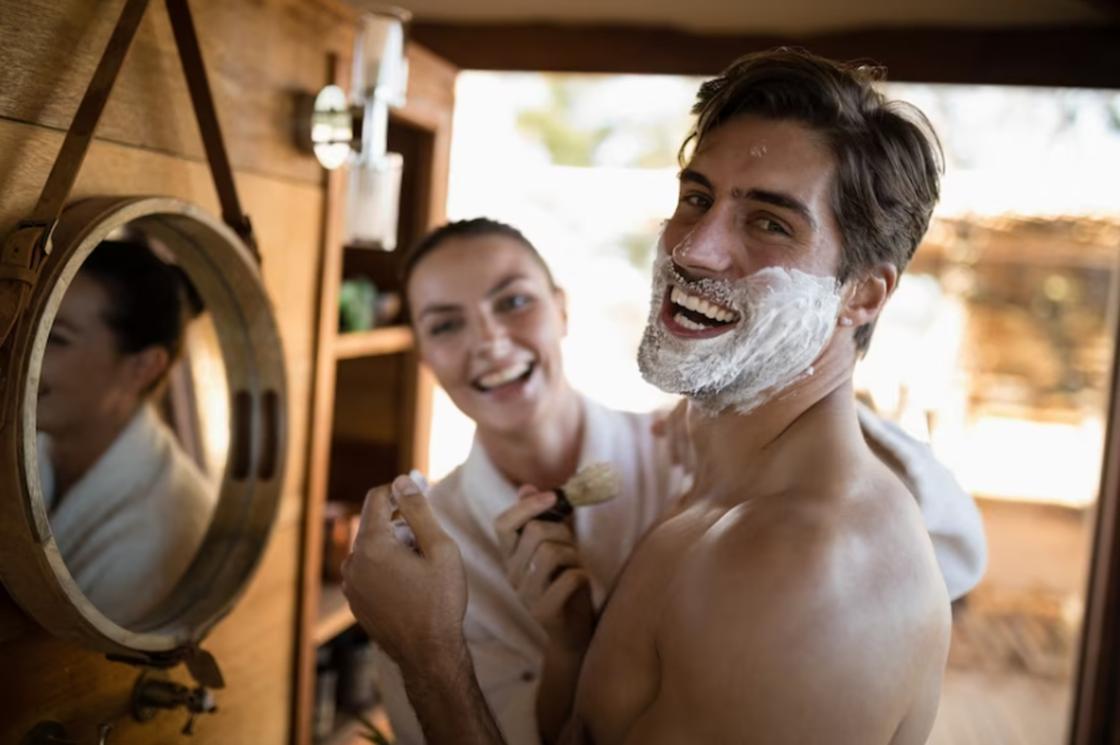 Женщина бреет мужчину