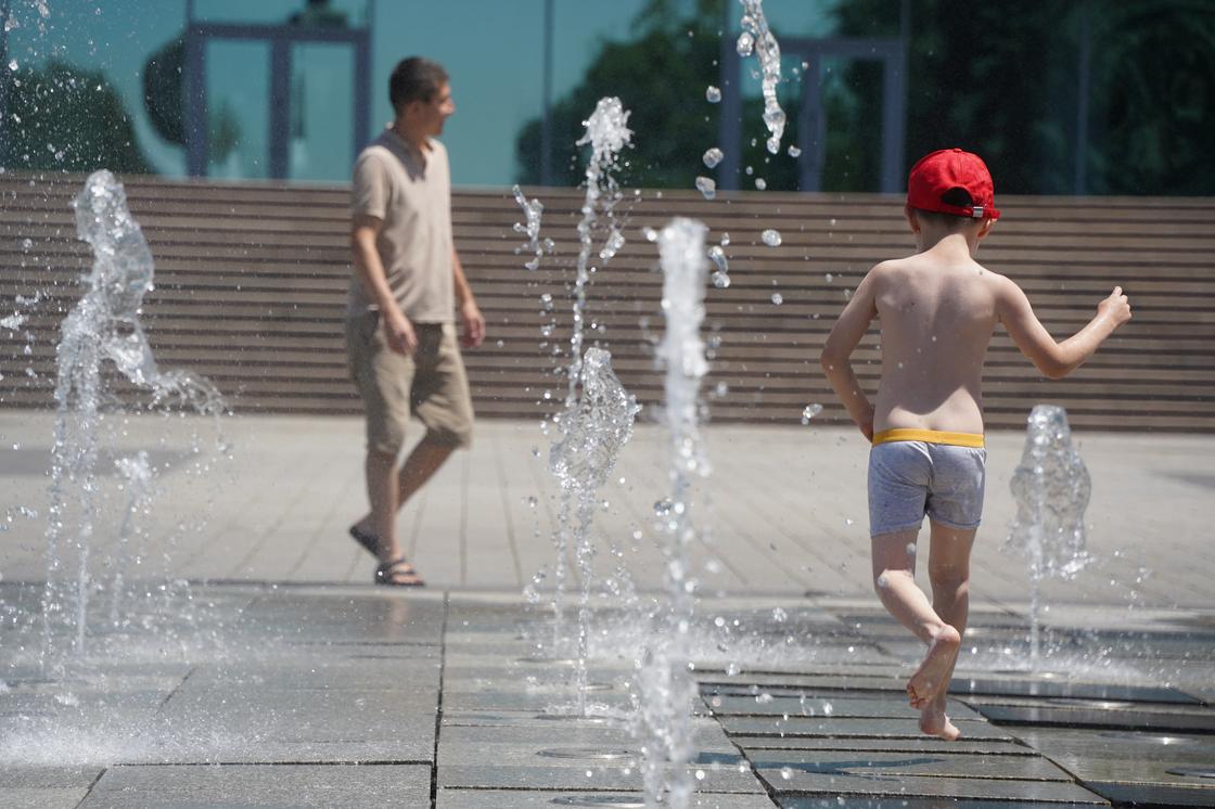 Мальчик бегает по фонтану