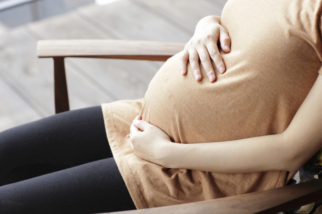 Беременная женщина сидит в кресле