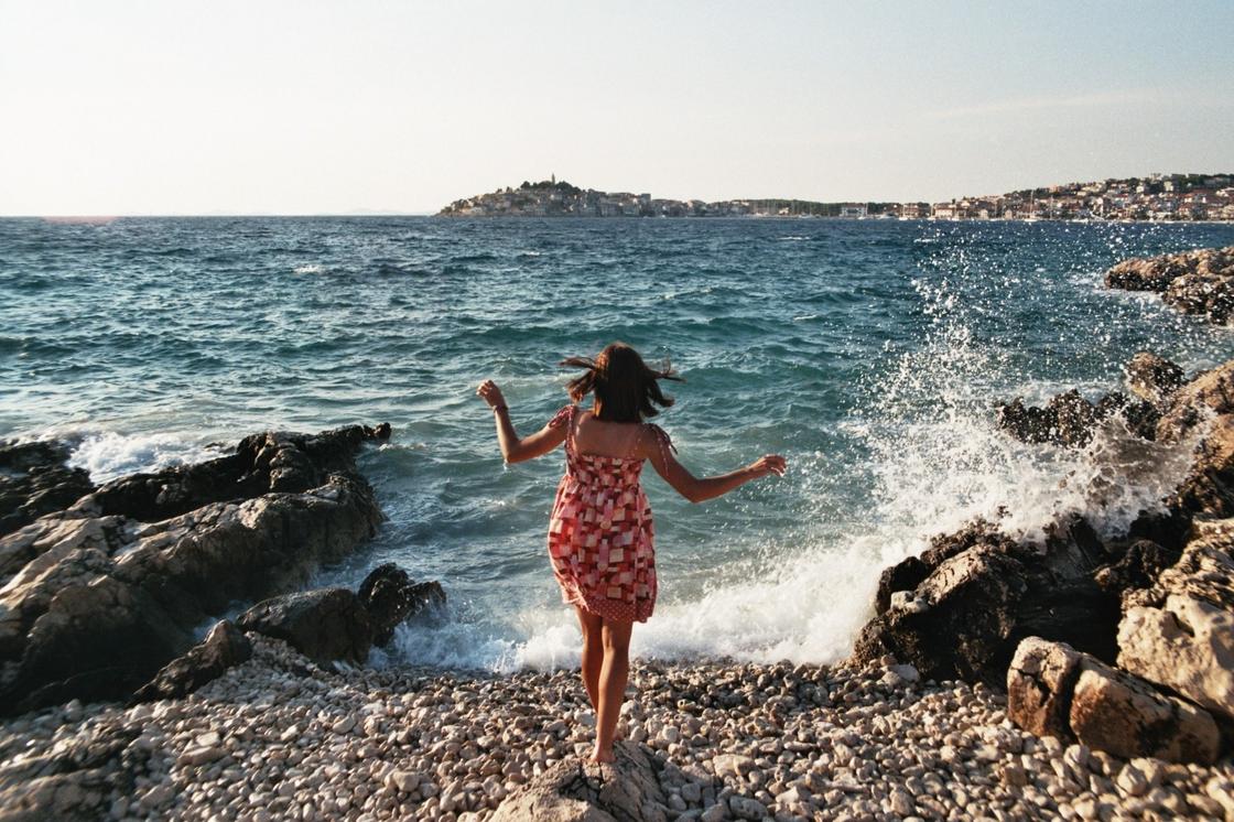 Девушка стоит на берегу моря