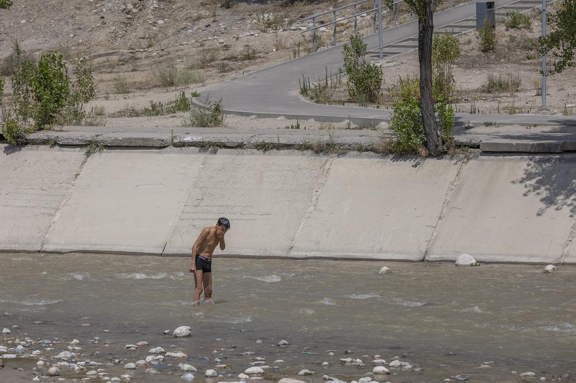 парень купается в реке Большая Алматинка