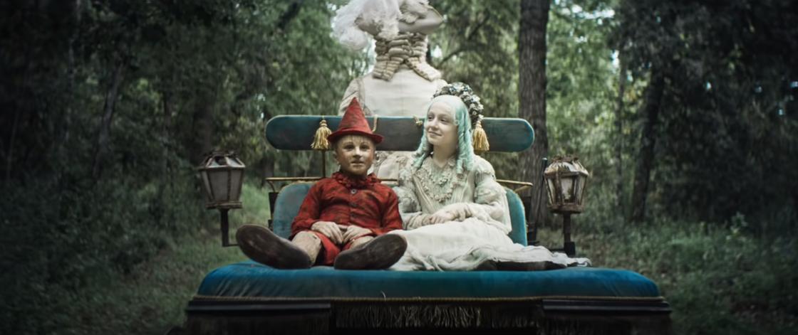 Пиноккио сидит рядом с голубоволосой феей. Кадр из фильма «Пиноккио» (2019)