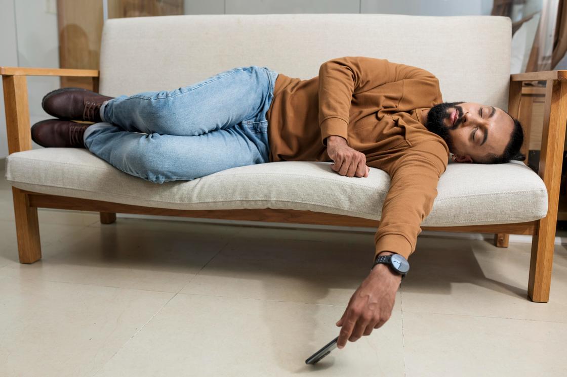 Мужчина заснул в неудобной позе на узком диване
