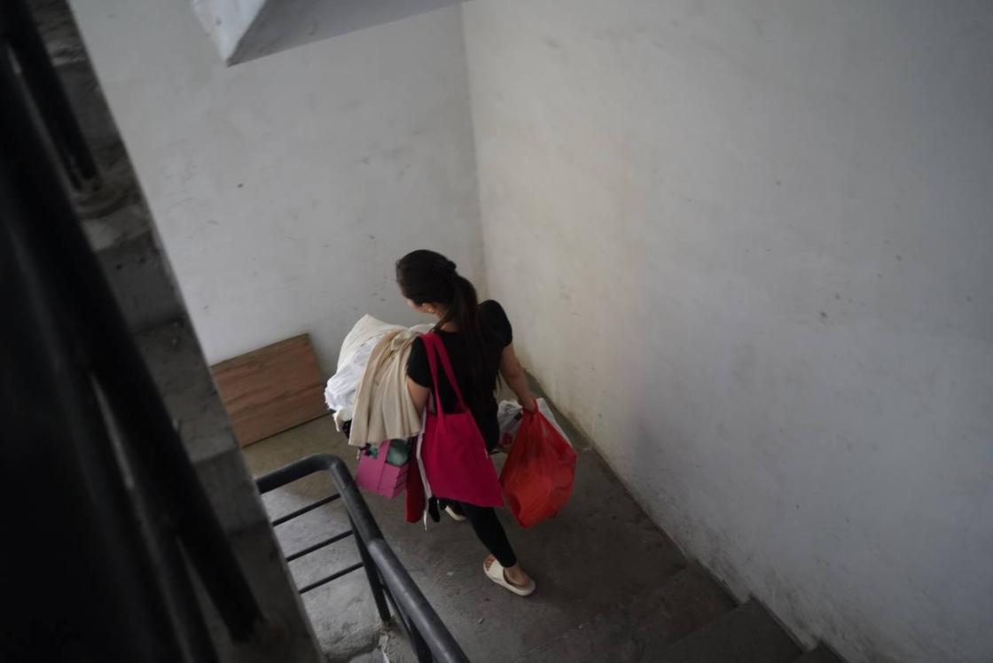 Девушка спускается с сумками по лестнице