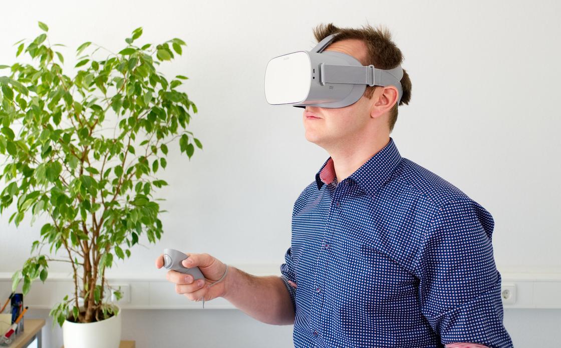 Мужчина стоит в очках виртуальной реальности