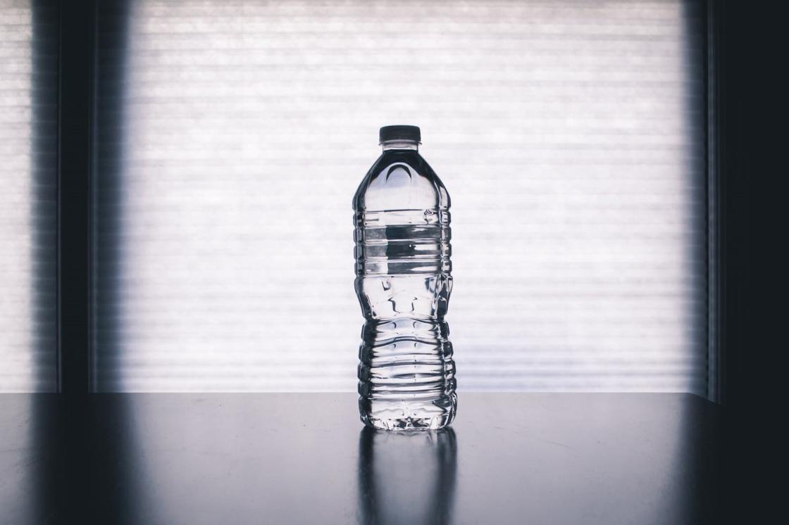 Бутылка воды стоит на столе